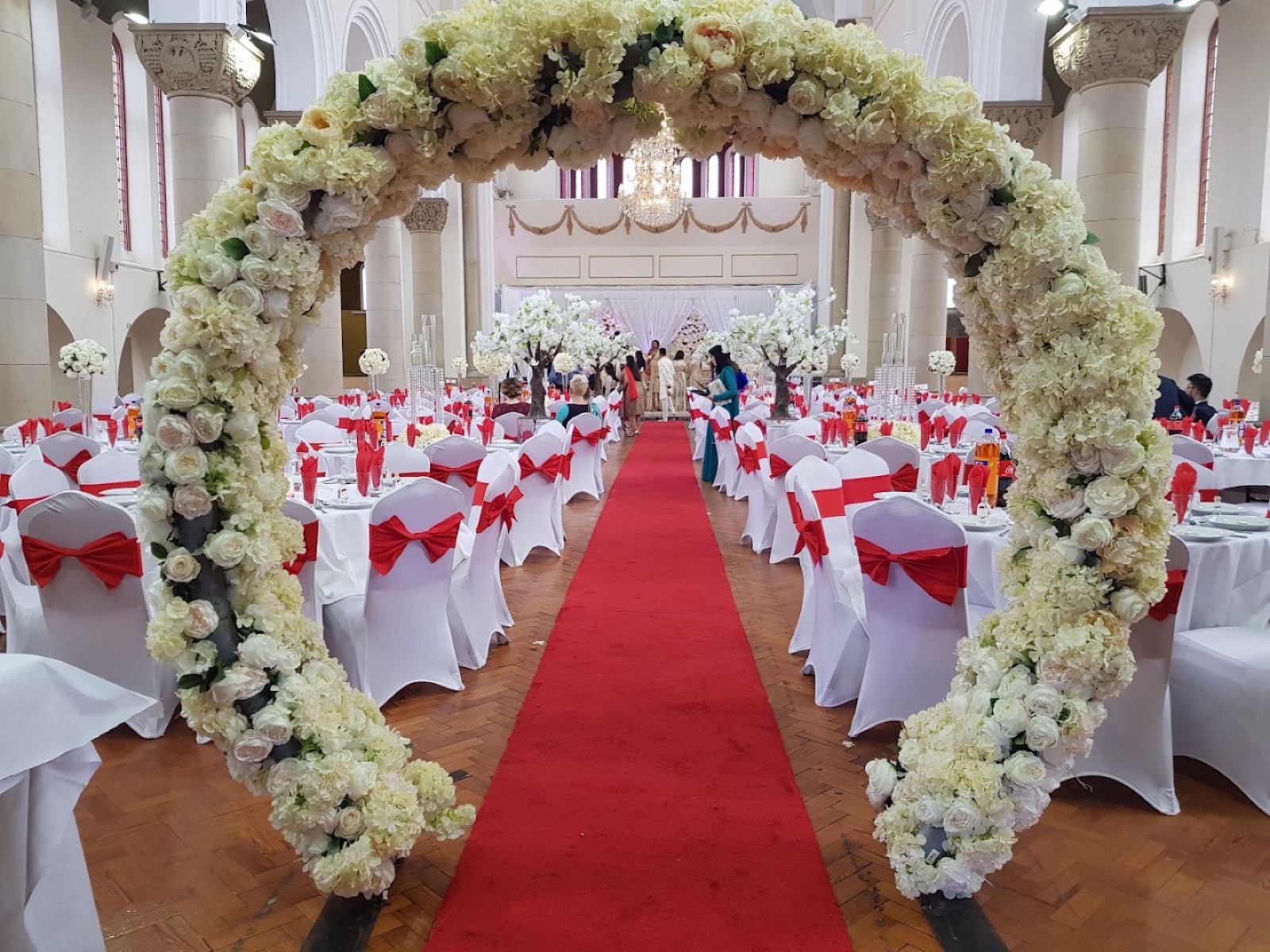 Floral arch and red carpet aisle